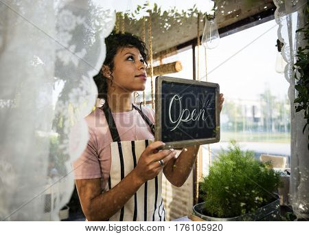 Woman Hanging Open Sign by the Glass Window
