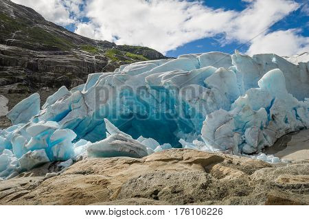 Close view of Nigardsbreen ice cave and melted water river landscape. Nigardsbreen Glacier, Norway.