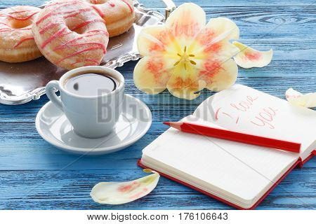 Cup Of Coffee On Turquoise Wooden Table With Open Flower Of Tulip