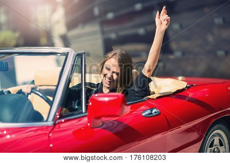 Portrait of beautiful sexy fashion woman model sitting in luxury retro cabriolet car