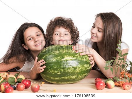 Little brother and two sisters enjoyed enormous variety watermelon. White background. Close-up.