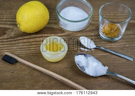 DIY toothpaste with ingredients coconut oil lemon turmeric baking soda Xylitol and bamboo toothbrush