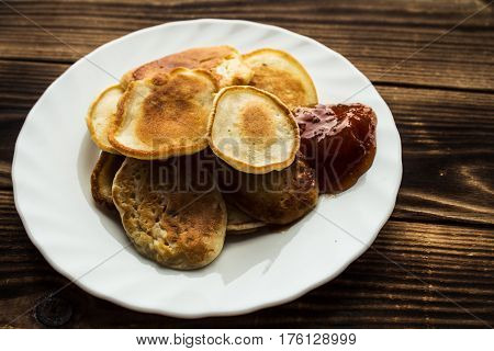 the homemade vegan pancackes with jam wooden background
