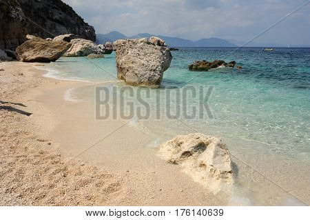 Cala Mariolu, Italy - 28 June 2013: people swimming and sunbathing at Cala Mariolu beach on Sardinia, Italy