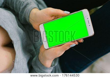 Beautiful girl holding a smartphone in the hands of a green screen green screen, hand of man holding mobile smart phone with chroma key green screen on white background, new technology concept