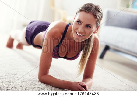 Fit girl in plank position at home in the living room