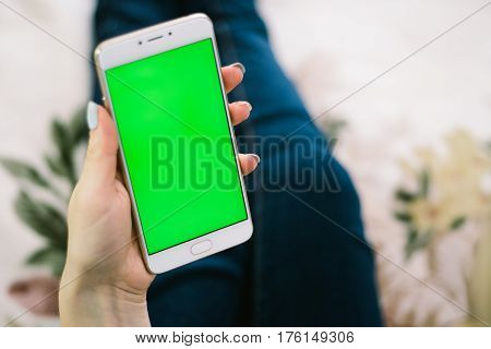 Beautiful girl holding a smartphone in the hands of a green screen green screen, hand of man holding mobile smart phone with chroma key green screen on white background, new technology concept