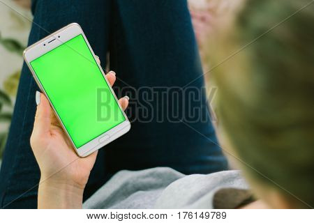 Beautiful girl holding a smartphone in the hands of a green screen green screen, hand of man holding mobile smart phone with chroma key green screen on white background, new technology concept