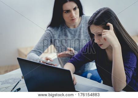Scared mother arguing daughter over online activity. Cyber bullying or blue whale game concept