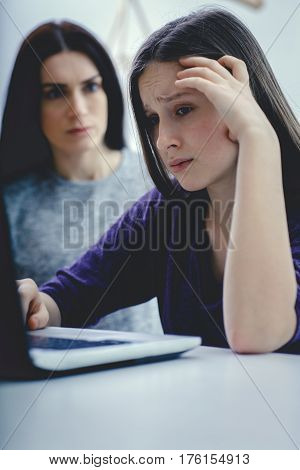 Scared mother arguing daughter over online activity. Cyber bullying or blue whale game concept