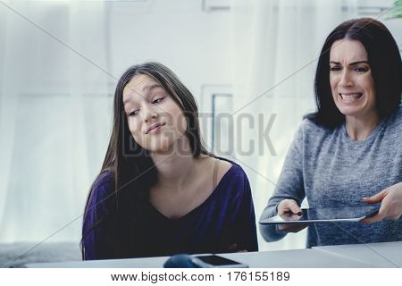 Scared mother arguing daughter over online activity. Cyber bullying or blue whale game concept