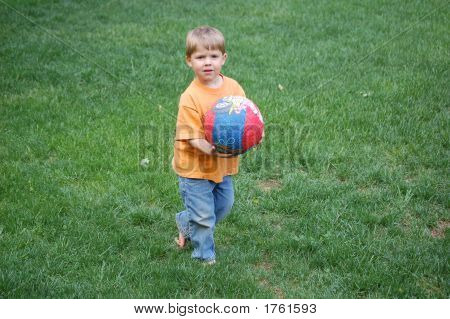 Menino segurando uma bola colorida