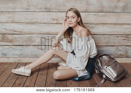 Fashion lifestyle portrait of young pretty woman sitting in wooden room. Processed with VSCO f3 preset
