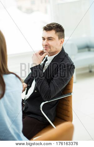photo successful employee sitting behind a Desk in the office . the photo has a empty space for your text.