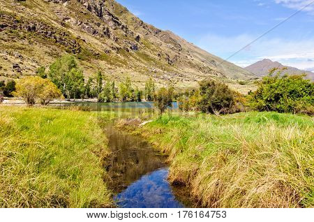 A little creek flows into Lake Wanaka at Glendhu Bay on the South Island of New Zealand