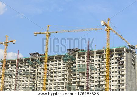 The under construction building and the crane with the blue sky