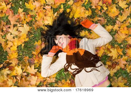 Giovane donna abbastanza sulla foglia d'autunno