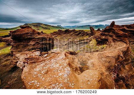 Red sandy rock with by magma formed by wind. Popular tourist attraction. Unusual and gorgeous scene. Location place Sudurland, cape Dyrholaey coast of Iceland, Europe. Artistic picture. Beauty world.