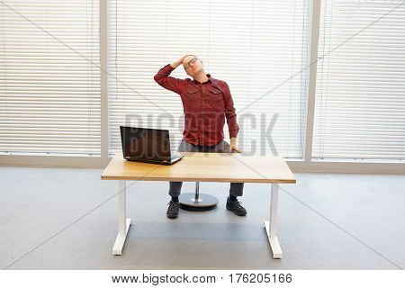 middle age balding man relaxing neck - short break for exercise on chair in office