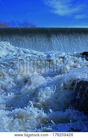 Small dam with flowing water. Vertical image