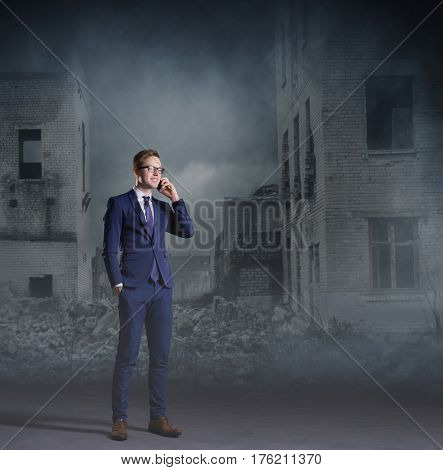 Businessman talking on a mobile phone. Apocalyptic background. Crisis, default, setback concept.