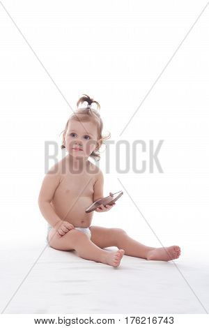Meeting technology. Adorable little girl in a diaper sitting on the floor holding a smart phone isolated on white technology children gadget mobility modern children childhood parenting concept