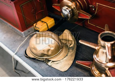 Golden Helmet Of Firefighter On Sidestep Of Fire Truck.
