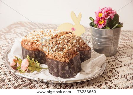 Easter dove on a board with lace tablecloth and a jar with primroses.