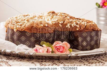 Easter dove on a board with lace tablecloth and a jar with primroses.