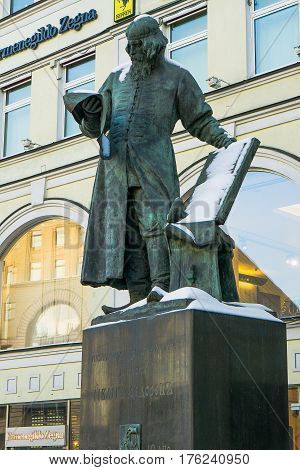 Moscow, Russia - January 30, 2017: Monument to the first printer Nikolai Fedorov in Moscow against the backdrop of the architectural structure