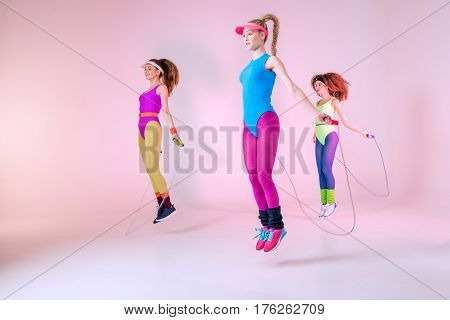 Young Sporty Women Jumping With Skipping Ropes On Pink