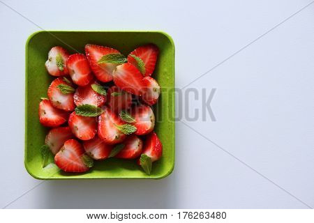 Fresh strawberry with leaves of mint on the white background.
