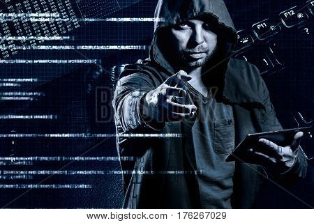 Internet crime concept. Dangerous hacker in hoodie shirt and dark digital background around stealing your data.