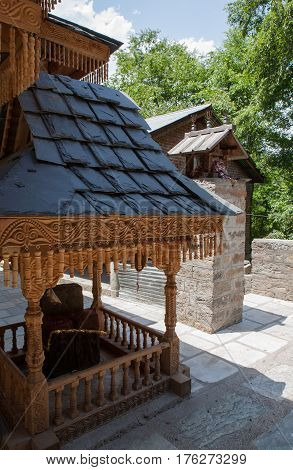 MANALI, INDIA. A small Shiva Temple decorated with wood-carved a swastika and iron tridents.  Naggar, district of Kullu in Himachal Pradesh, India.