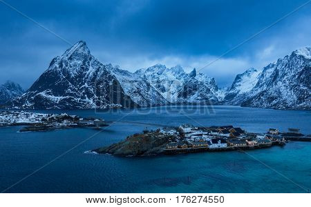 Cold day on Lofoten islands Nordland Norway. Grey winter clouds over bay of Reine - picturesque village located on few islands.