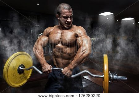 Athlete Muscular Bodybuilder In The Gym Training Biceps With Bar