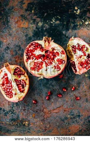 Parts Of Pomegranate Fruit On Black Rustic Sufrace.
