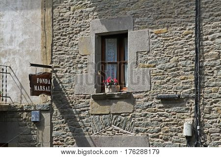 Rupit Spain - September 09 2014: Window with flowerpot and signboard of hotel in Rupit (Catalonia Spain)