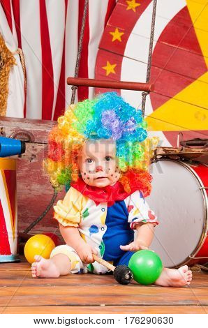 Little baby clown with red nose multi-colored wig in with balls.