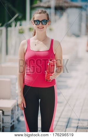 young athletic girl perfoms exercises in the gym running sports and exercieses in the park