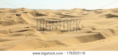 Panoramic view of big sand dunes landscape. Desert or beach sand with ocean in background.