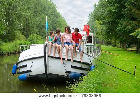 Family vacation, travel on barge boat in canal, happy kids having fun on river cruise trip in houseboat