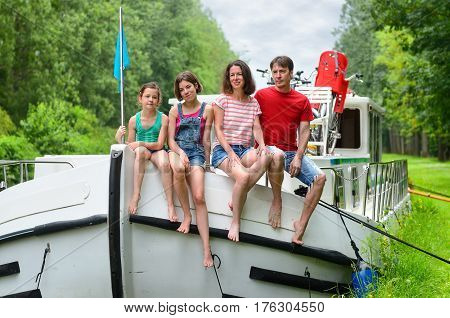 Family vacation, travel on barge boat in canal, happy kids having fun on river cruise trip in houseboat