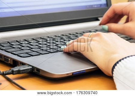 Woman's hand on laptop keyboard. Selective focus