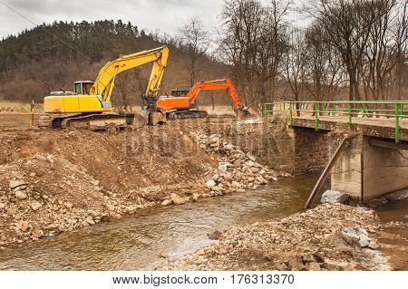 Flood adjustments river. Work on the riverbed. Excavator on the work to strengthen the shoreline of the river