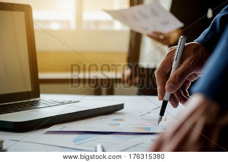 Business concept. Business people discussing the charts and graphs showing the results of their successful teamwork. Selective focus