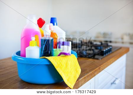 Basket With Cleaning Items On Blurry Background White Citchen. Cleaning Concept.