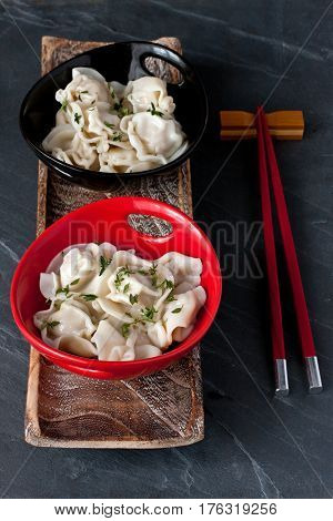 Meat dumplings  in ceramic pot on dark stone background. Asian style serving