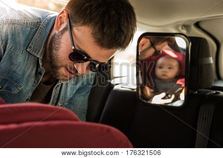 Father Fasten His Baby In Car Seat