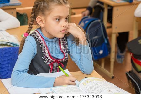Girl Schoolgirl Sits At A School Desk At A Lesson At School